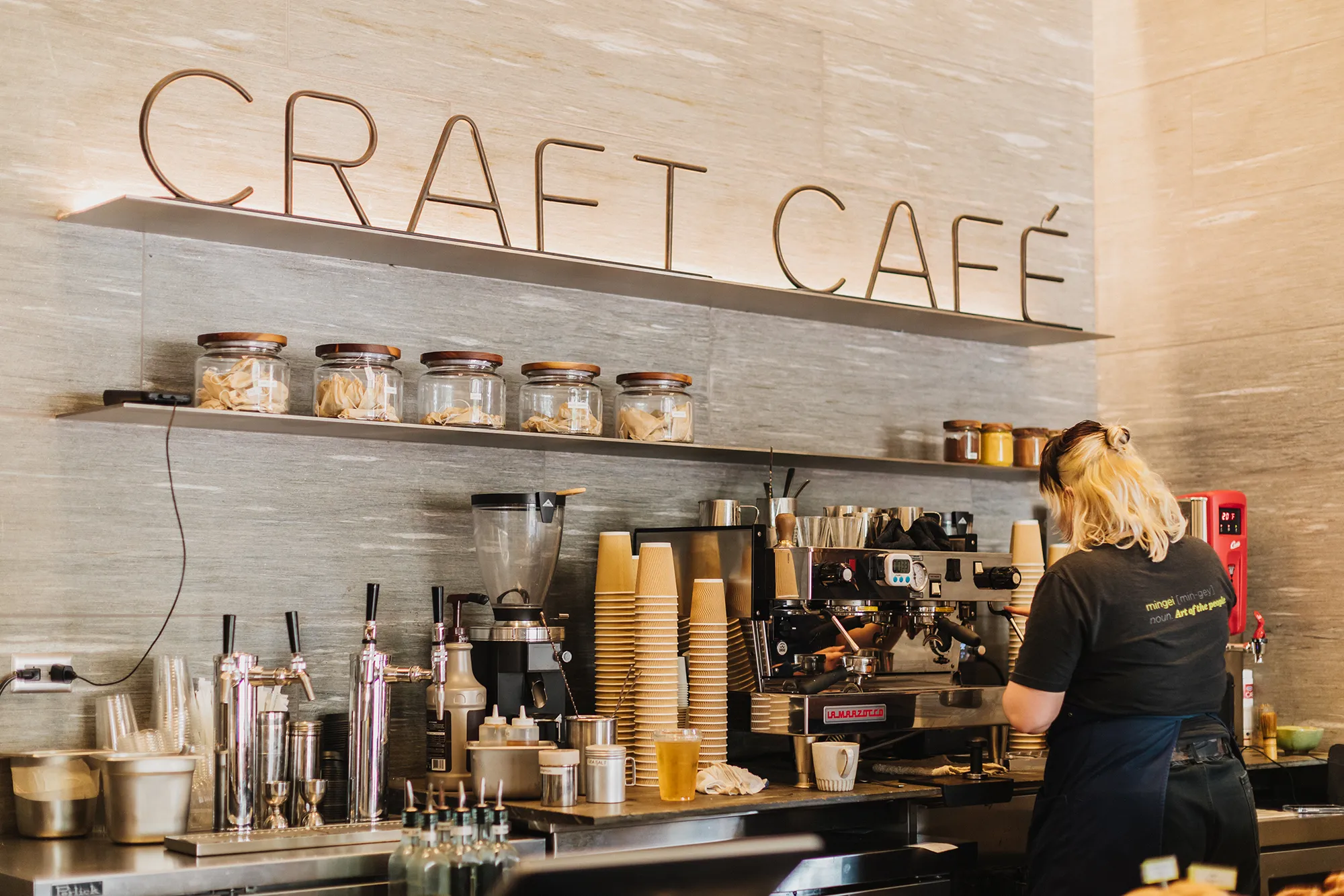 A staff member working with an espresso machine at Craft Cafe