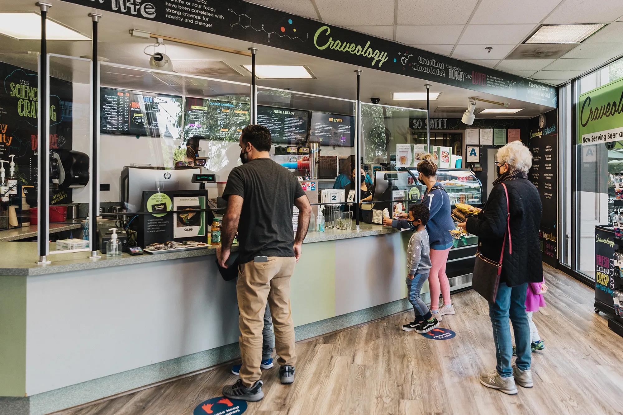 People standing in front of Craveology counter ordering.