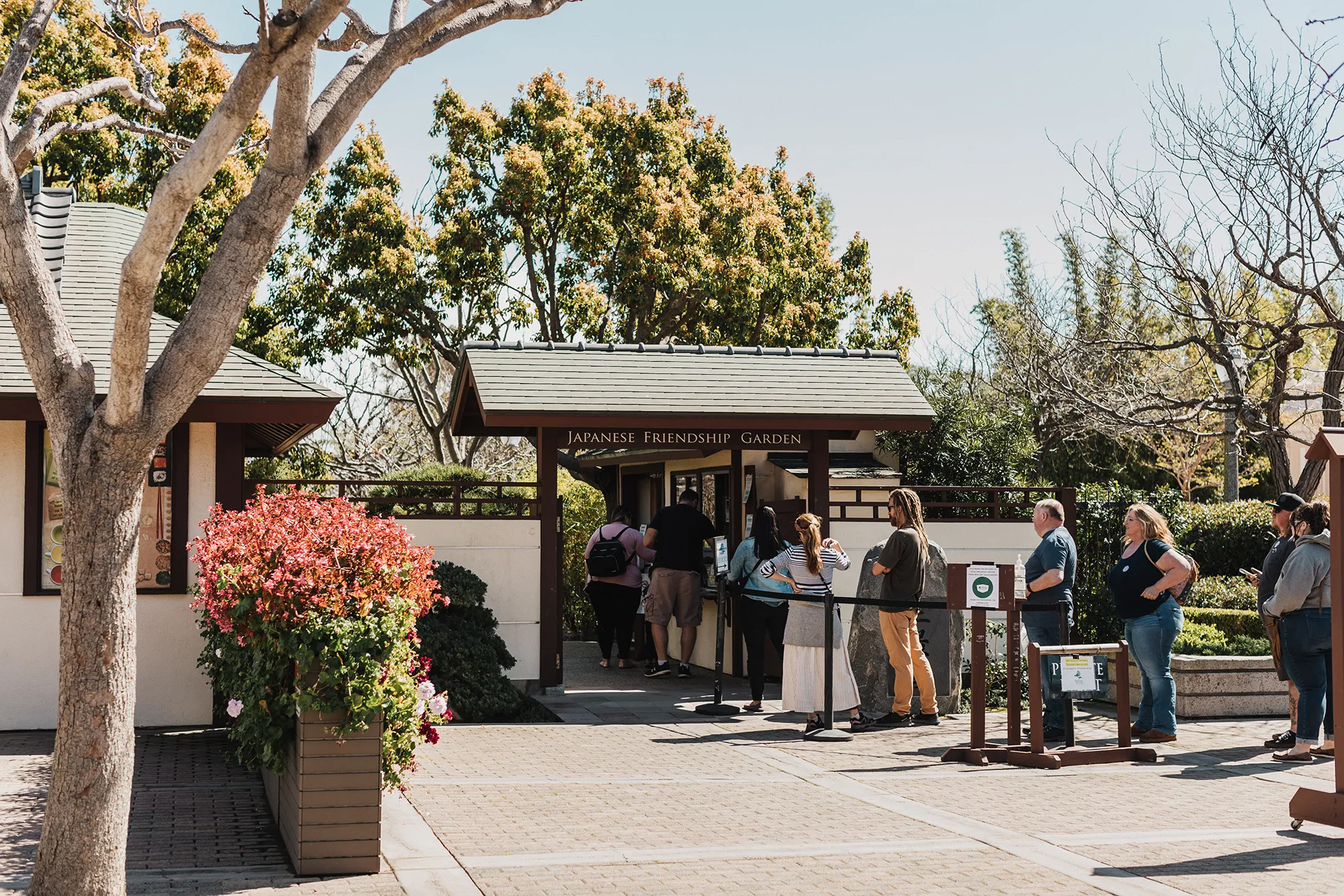 Japanese Friendship Garden entrance with a line of visitors waiting to go in.