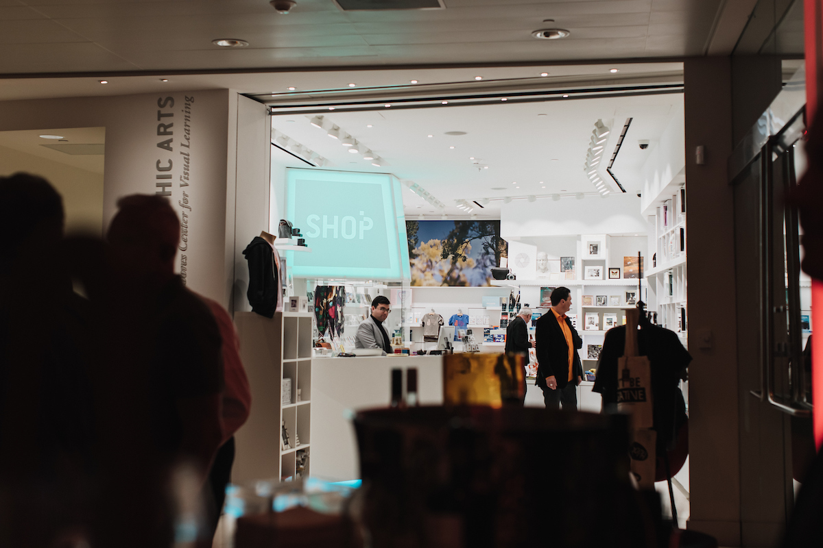 People looking at items for sale in the MOPA@SDMA shop.