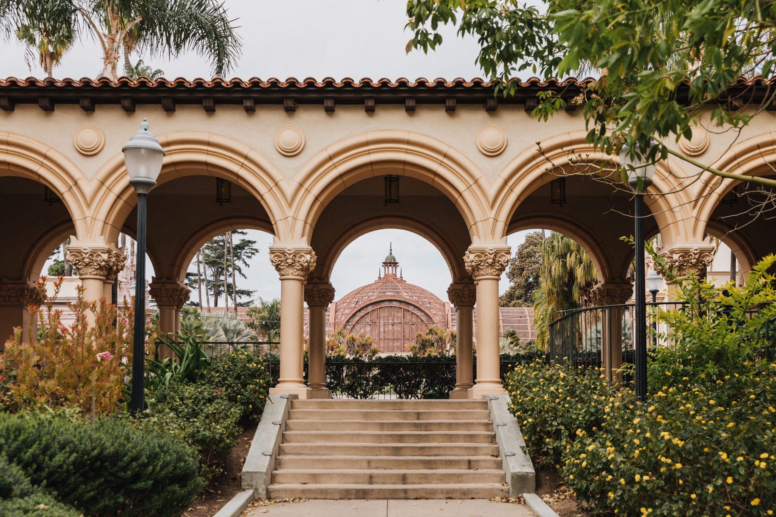 A view of the Balboa Park Botanical Building roof looking through the arch of a covered walkway.