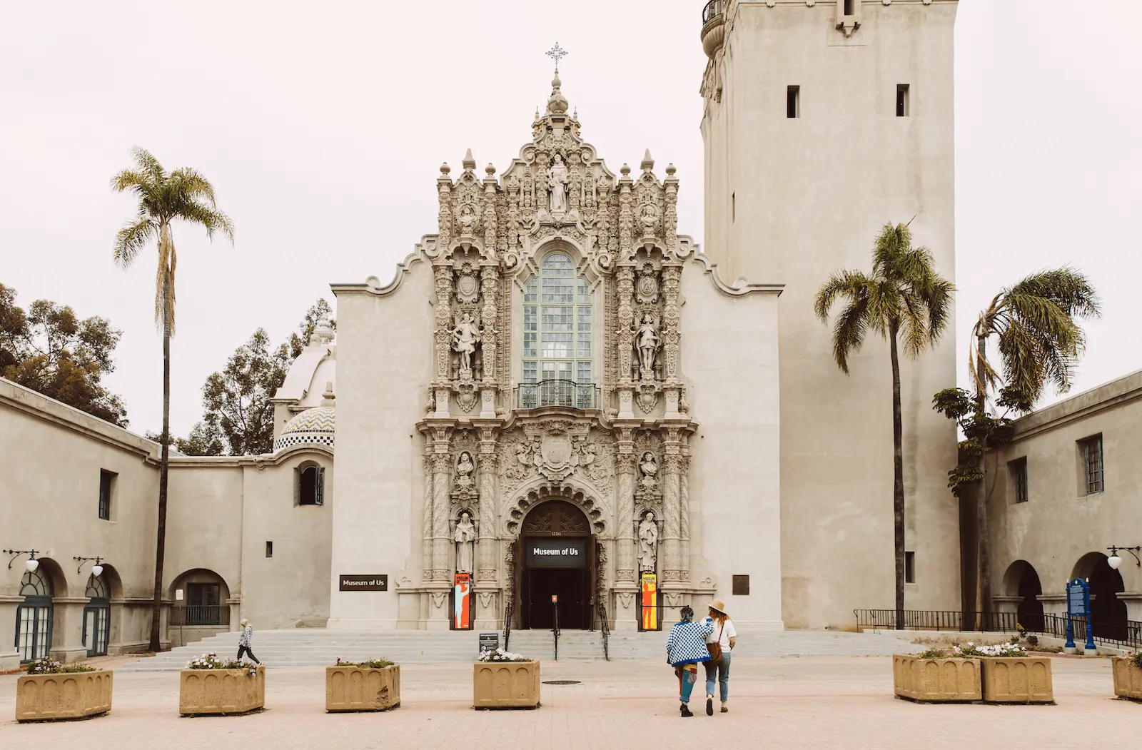 Two people walking towards the front entrance of the Museum of Us.